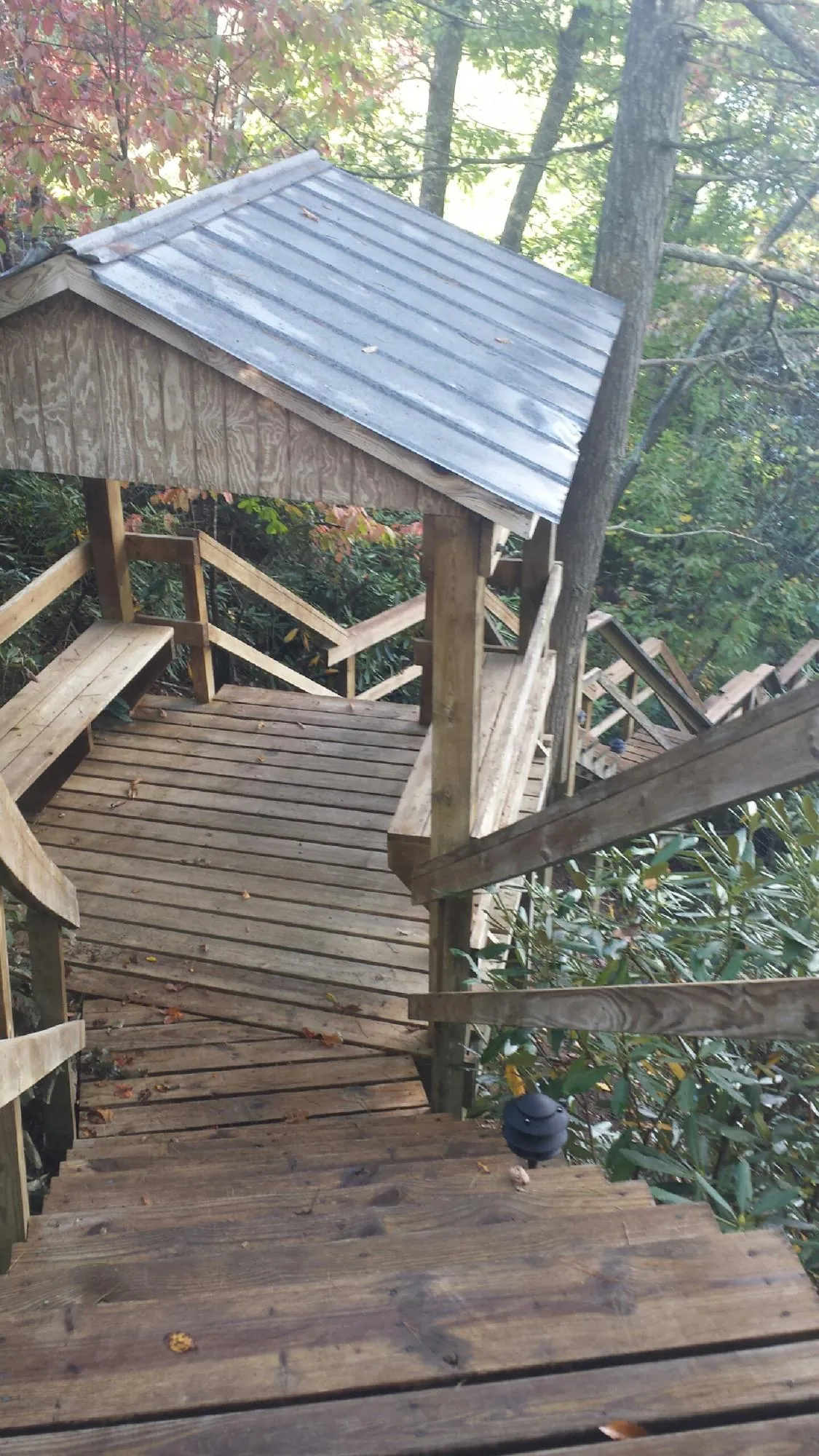 Metal roofed shelter over wooden steps on a wooded walkway — Skylight Repair & Installation work by our crew in Park City