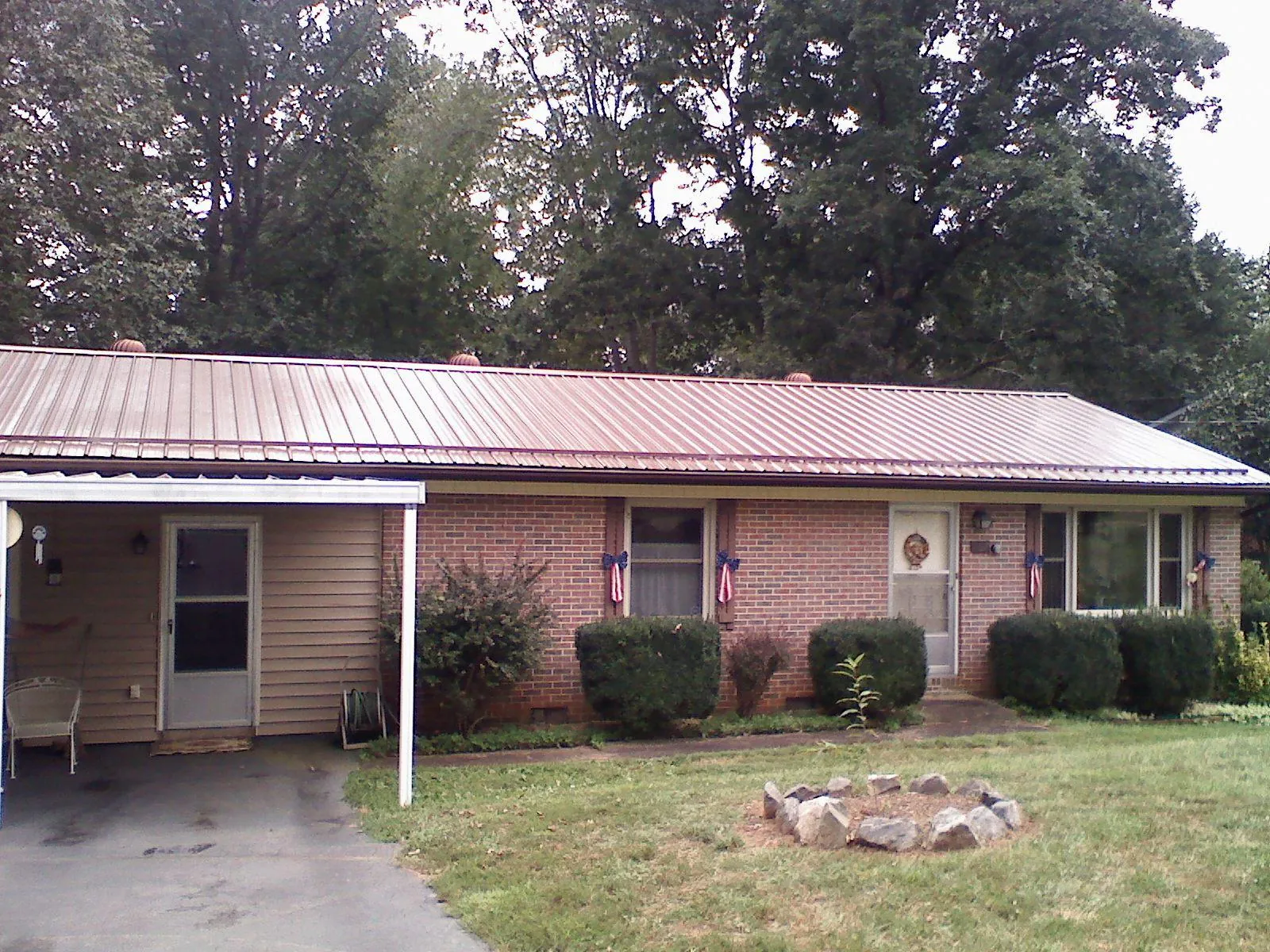 Bronze metal roof and carport on a brick ranch home — Roof Repair work by our crew in Park City
